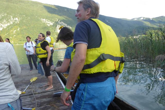 Mehrere Personen in gelben Schwimmwesten stehen auf einem Steg