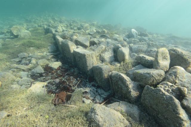 Unterwasserfoto einer römischen Anlage mit Bohlenwänden und Steinschüttung