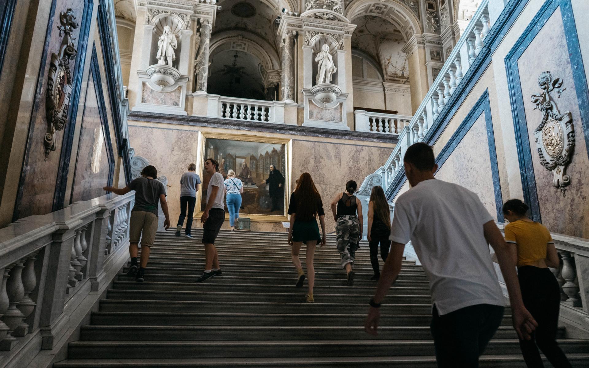 Eine Gruppe von Personen steigt die Treppe des NHM hoch