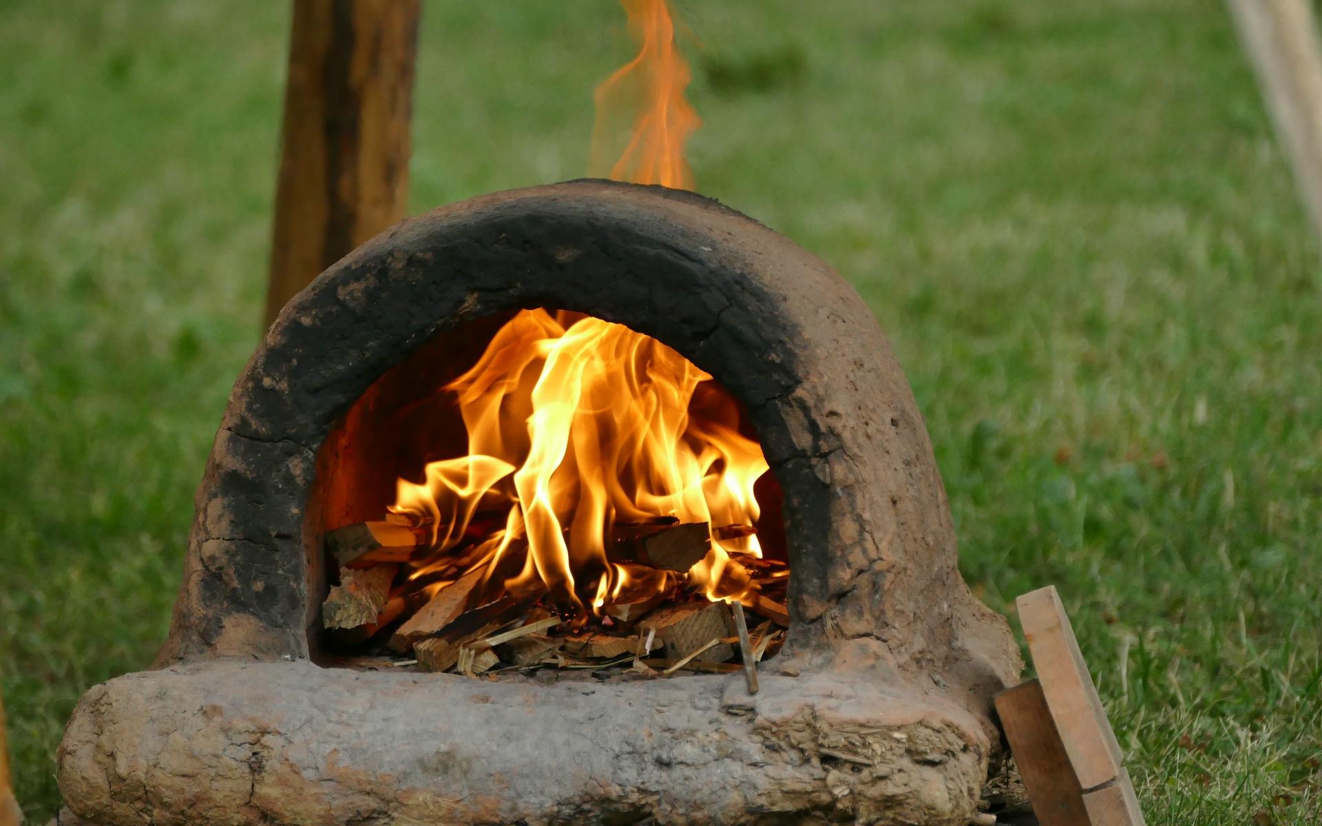 Lehmbackofen mit offenem Feuer beheizt