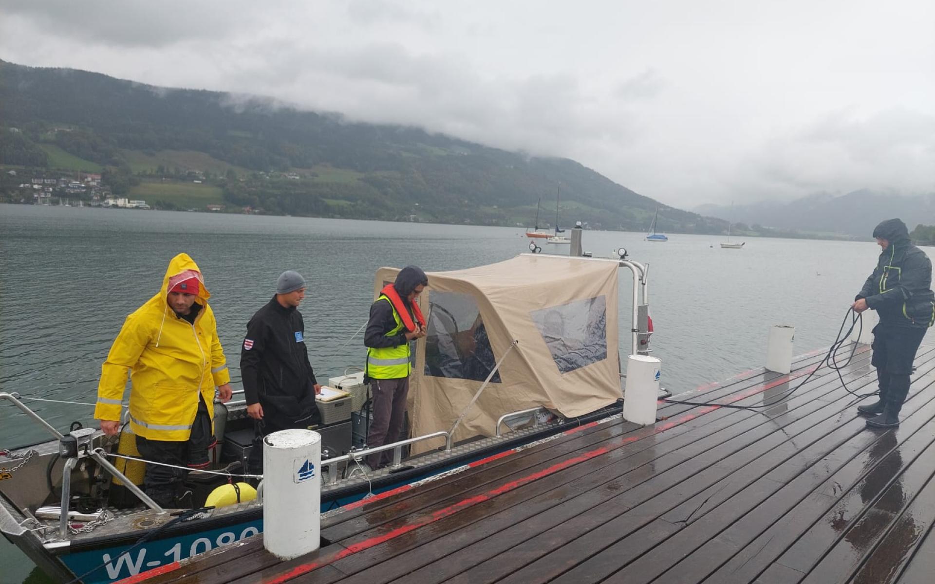 Mehrere Personen steigen auf ein Boot am See