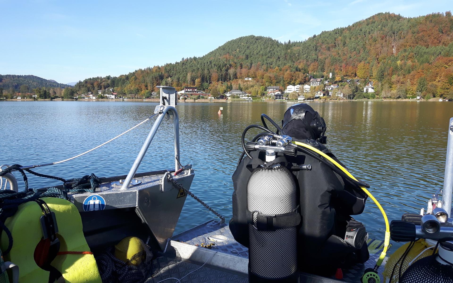 Ein Taucher, der am Boot sitzt, kurz bevor er in den See einsteigt