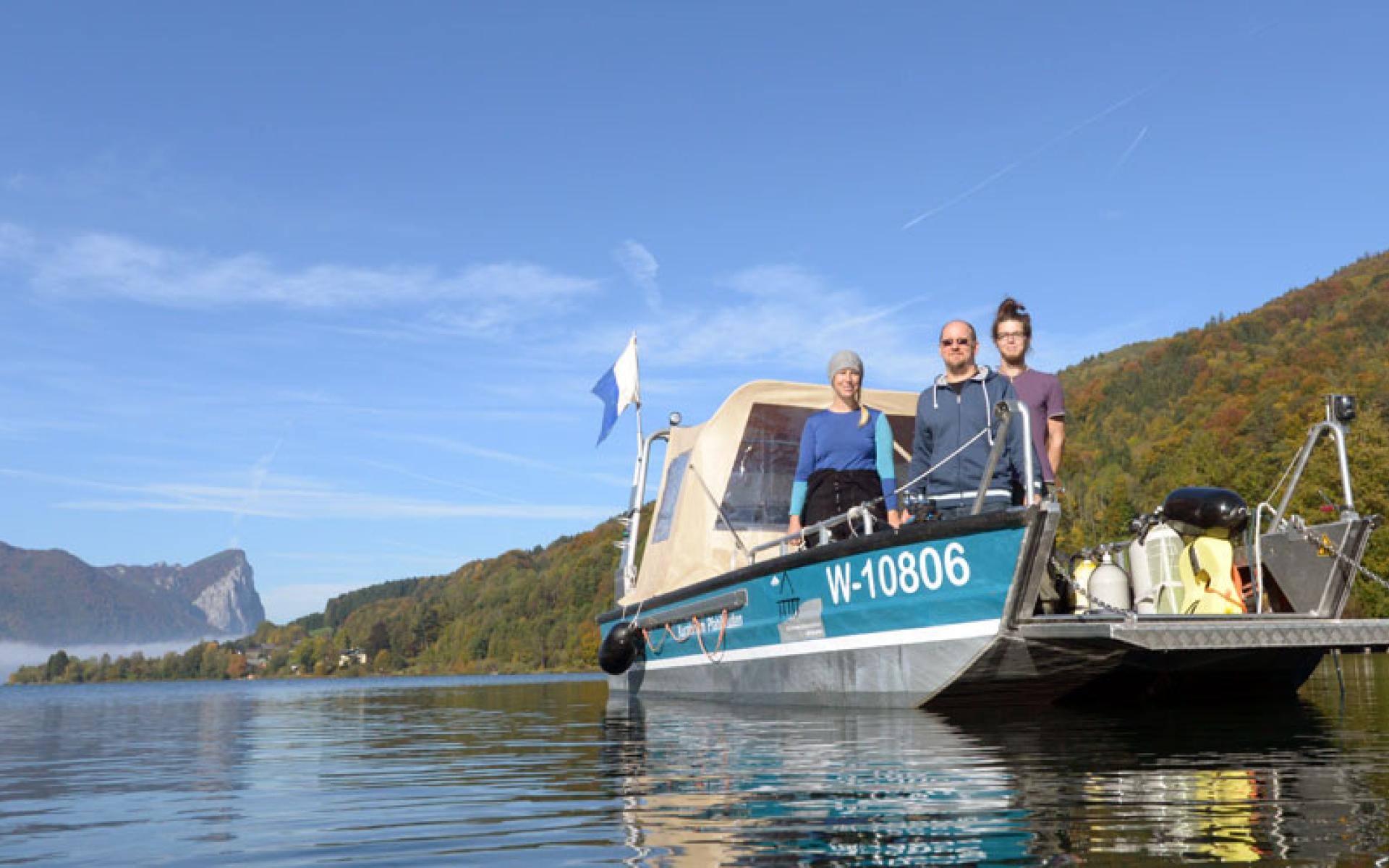 3 Personen auf einem Boot, das im See schwimmt