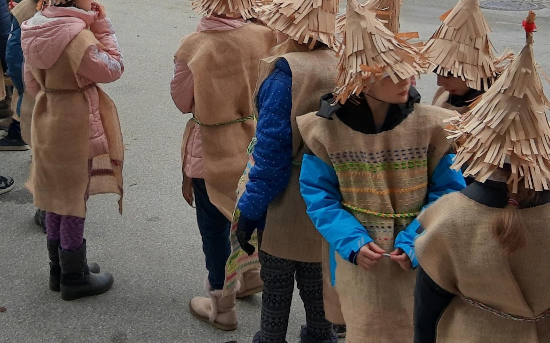 Eine Kindergruppe mit Kostümen aus brauner Jute 