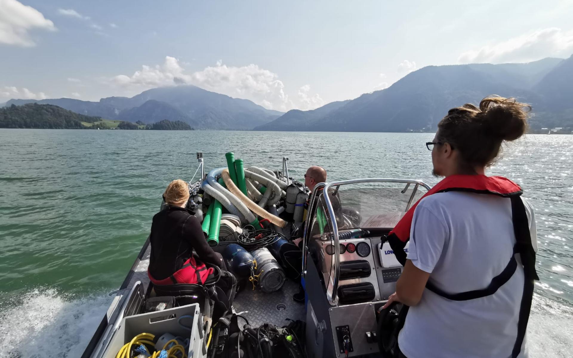 Mehrere Personen auf einem Motorboot am See