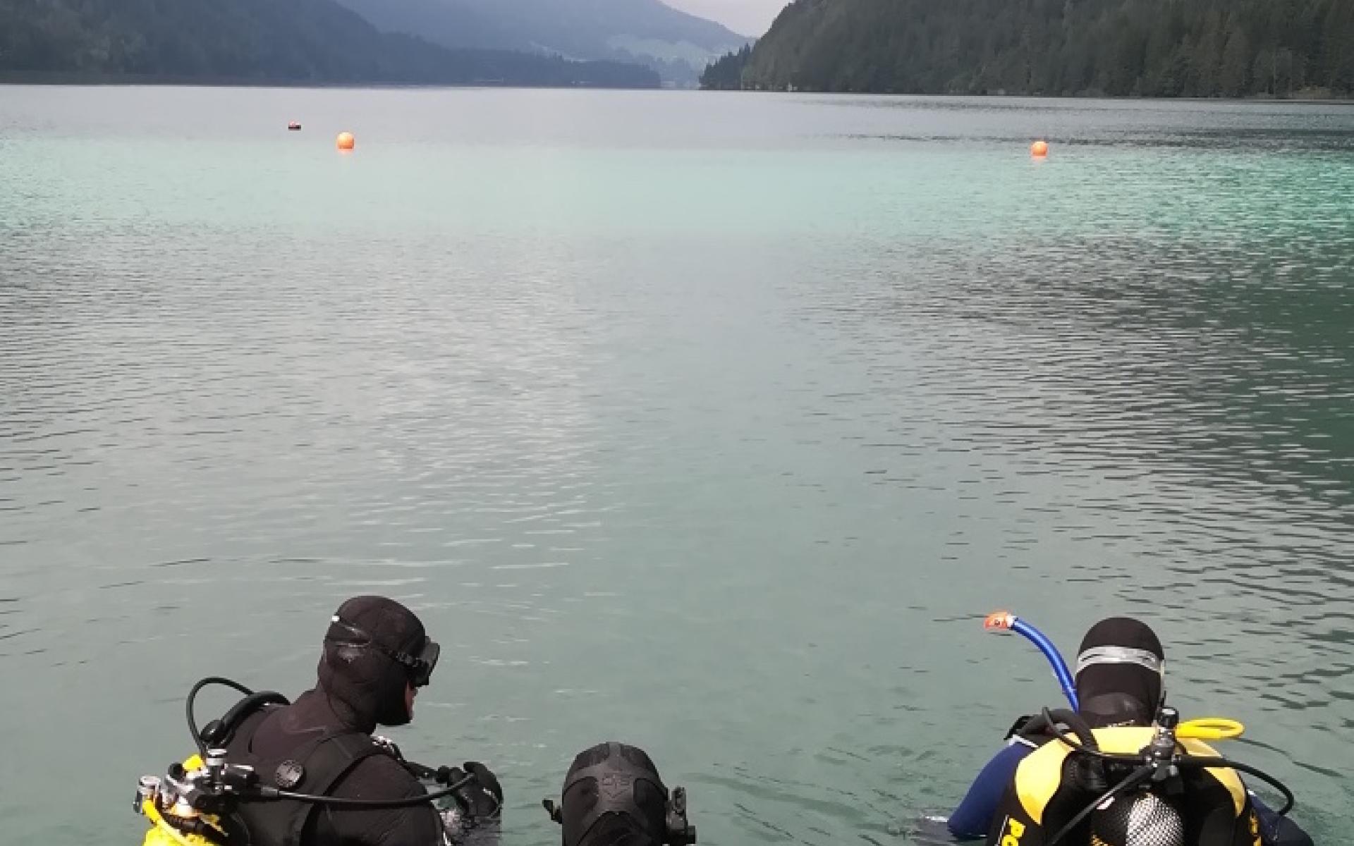 3 Taucher halb im Wasser des Weissensees