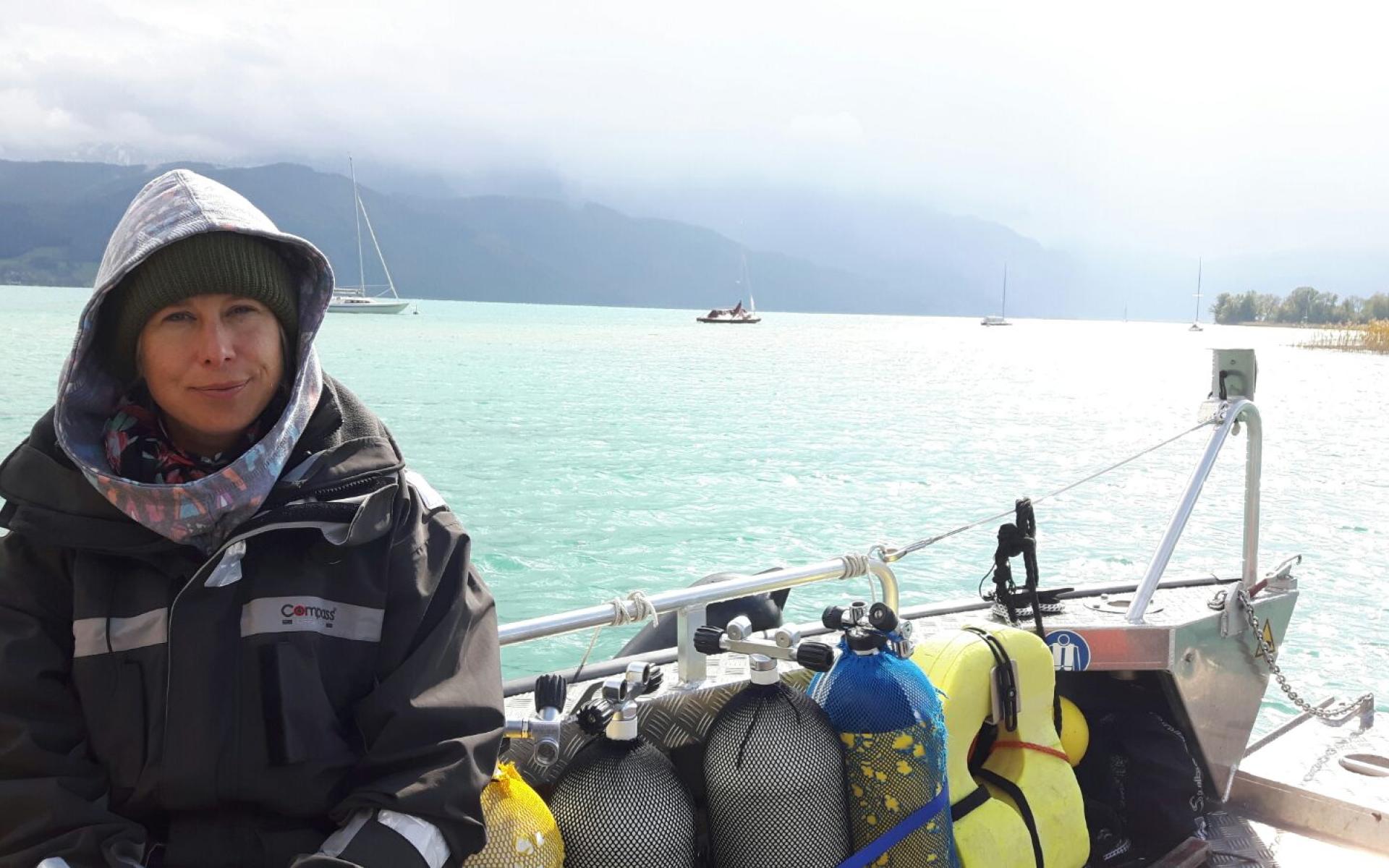 Esther sitzt neben den Tauchflaschen auf dem Boot