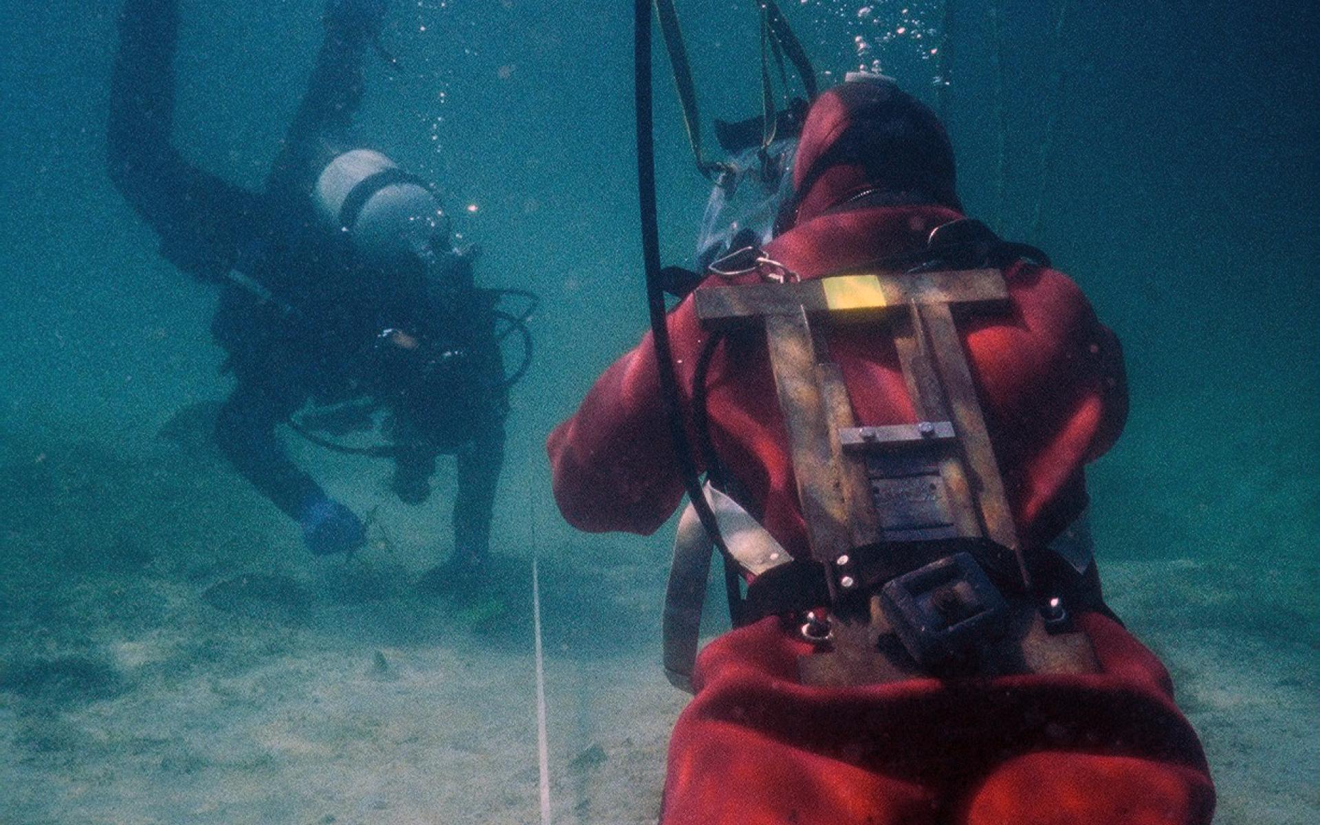 2 Taucher unter Wasser untersuchen den Seeboden
