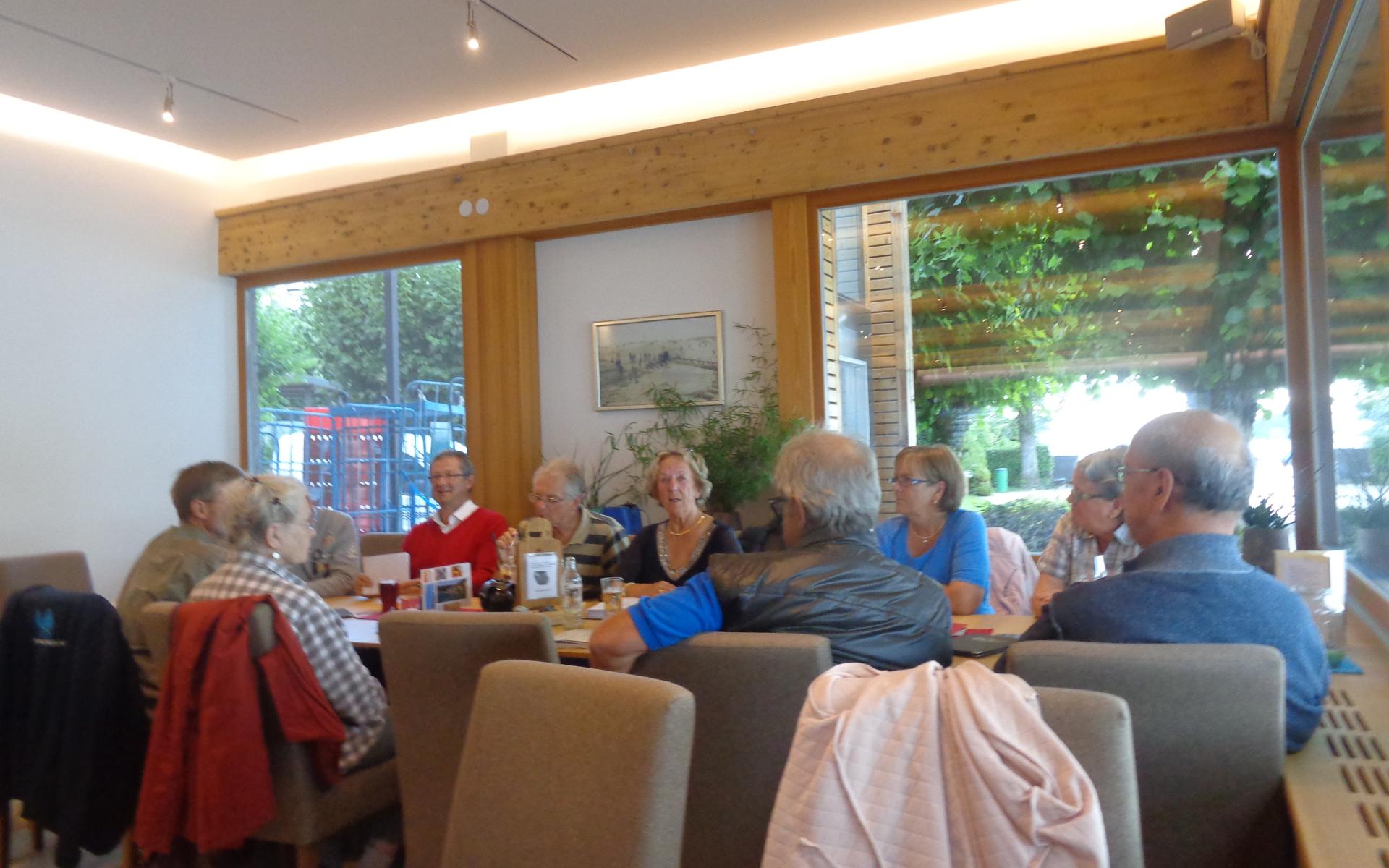 Die Vereinsmitglieder sitzen in einem Gasthaus an einem großen Tisch