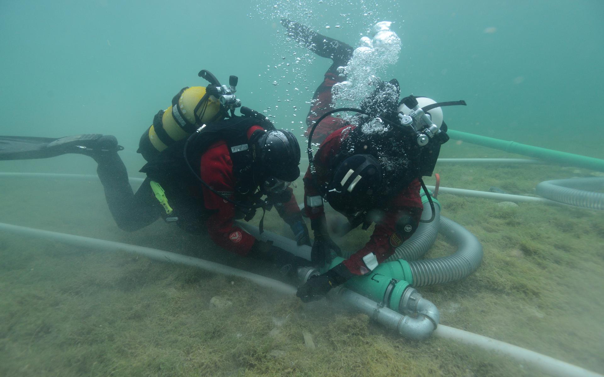 2 Taucher im Unterwasserschnitt bei der Arbeit mit der Dredge