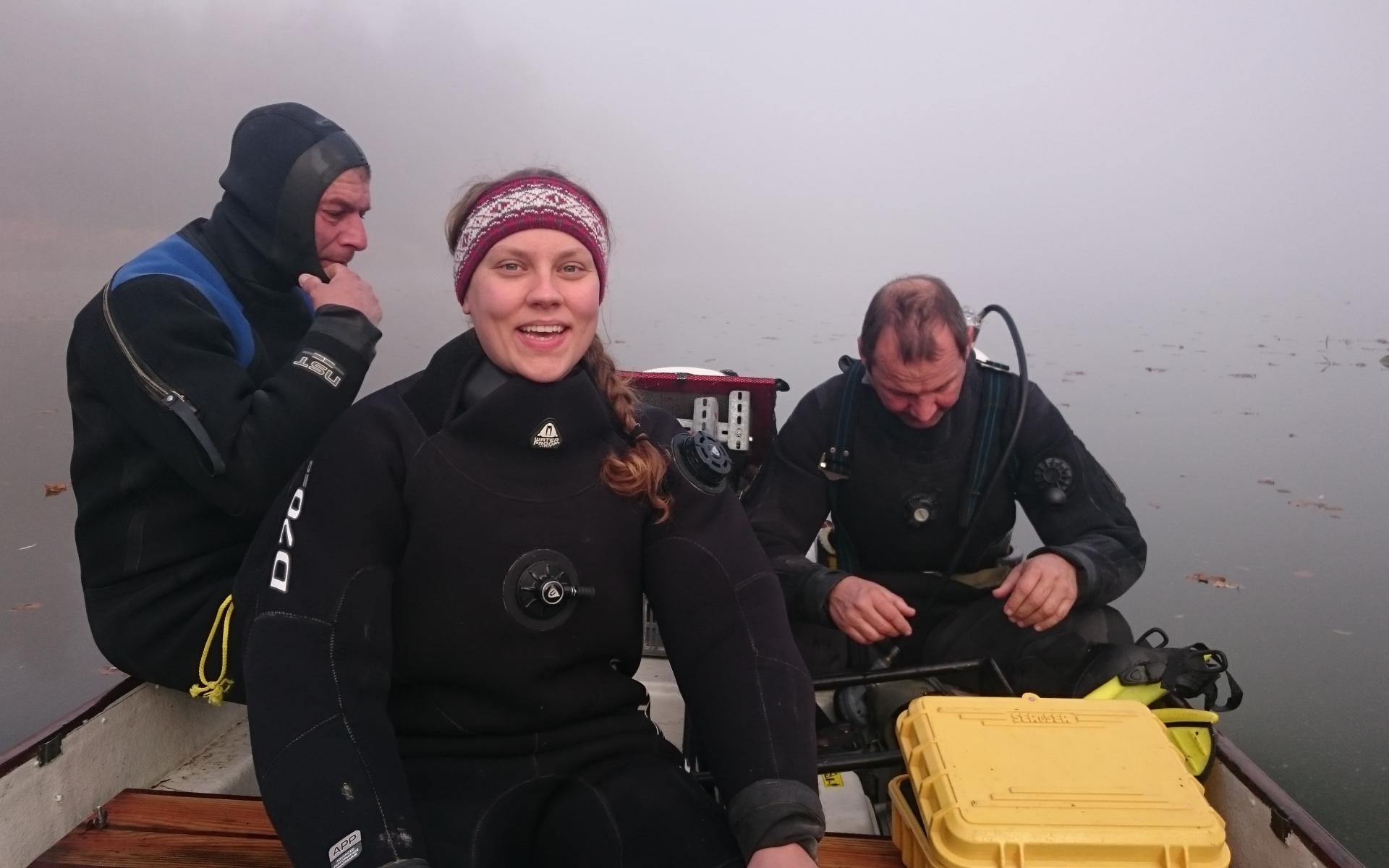 3 Personen sitzen auf einem Boot im Nebel