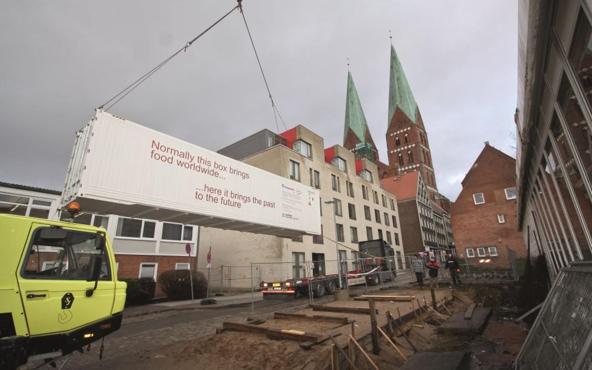 Ein Kran hebt den Container auf den LKW