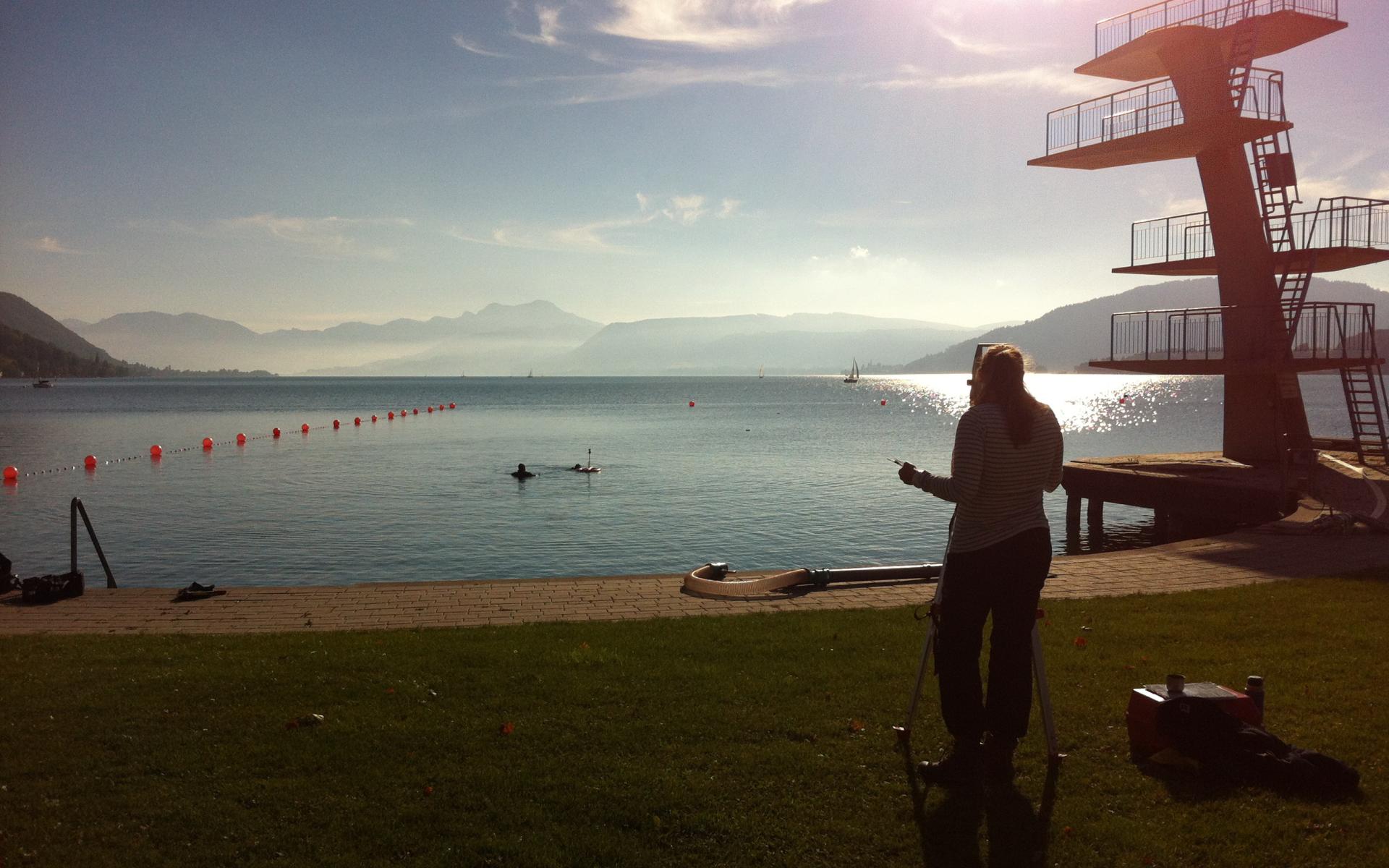 Helena am Tachymeter vor dem Attersee und dem Sprungturm in Seewalchen