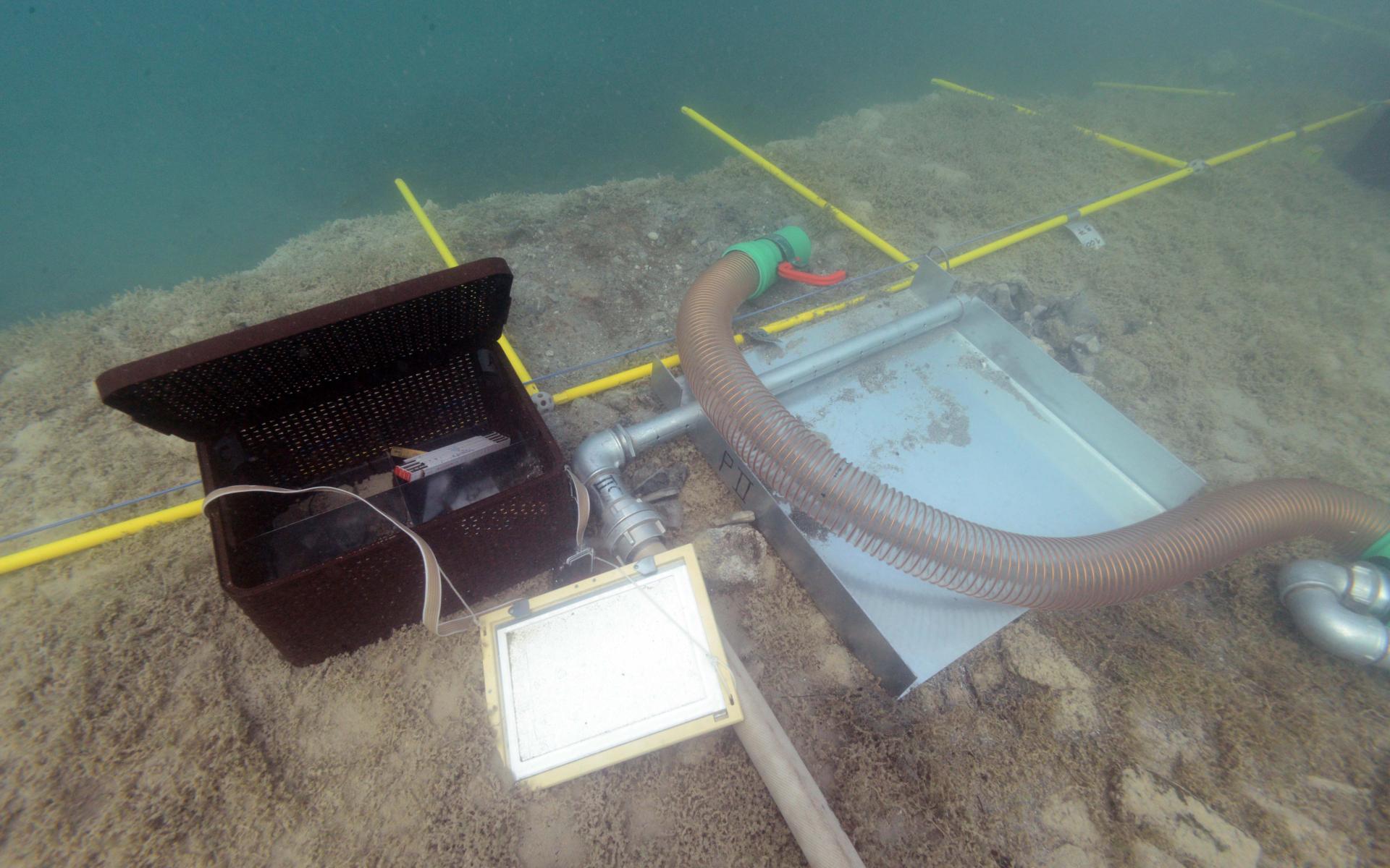 Eine schwarze Box, eine Schreibtafel, die Waterdredge und die Vermessungsrahmen unter Wasser