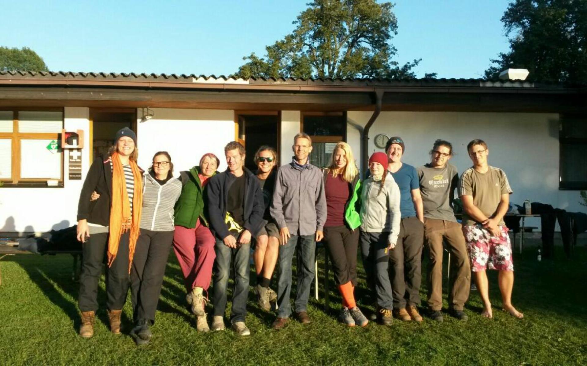 Das Grabungsteam auf einer Wiese vor einem niedrigen Gebäude