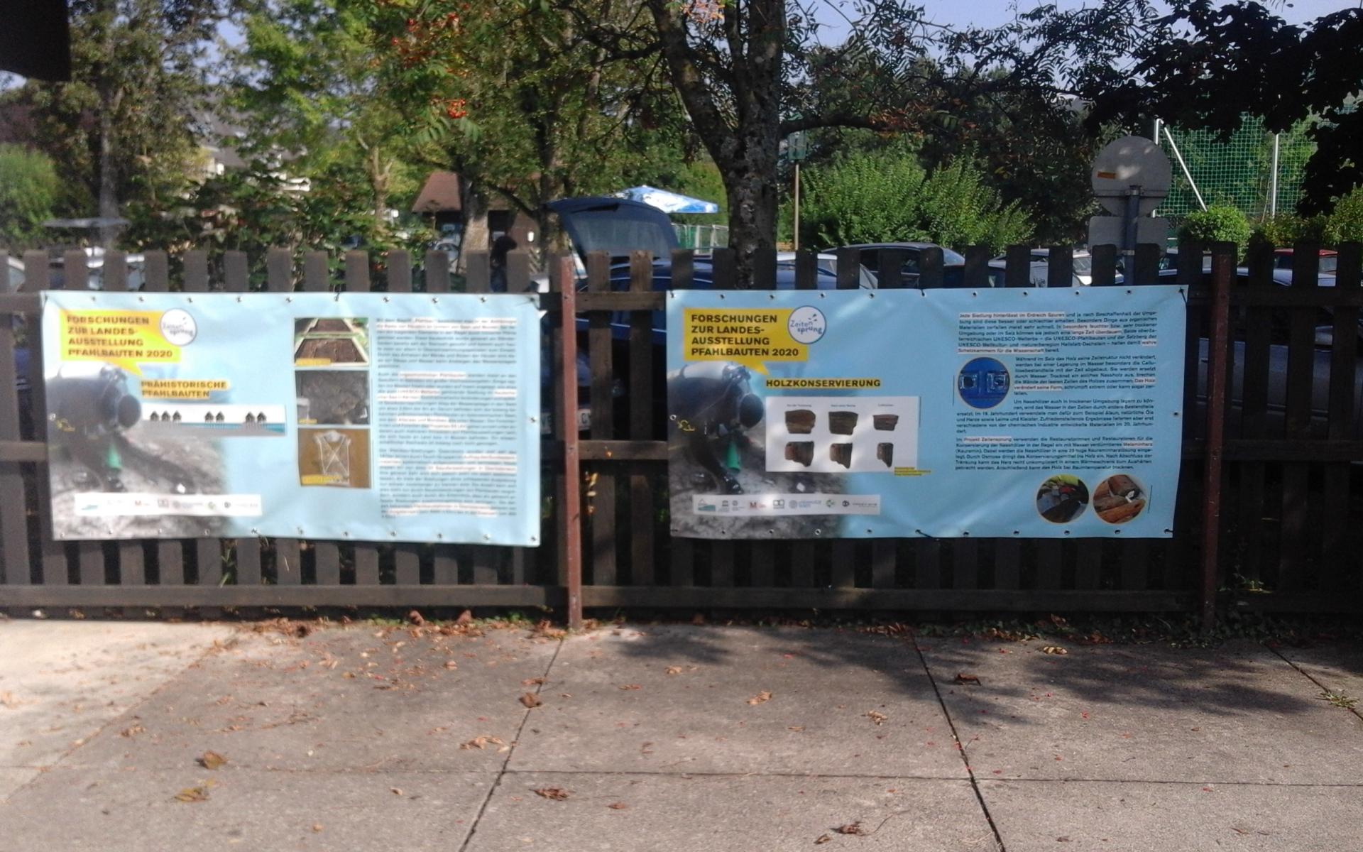 2 Plakate auf einem Zaun montiert