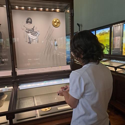 Klara Ansari vor einer Vitrine im NHM Wien