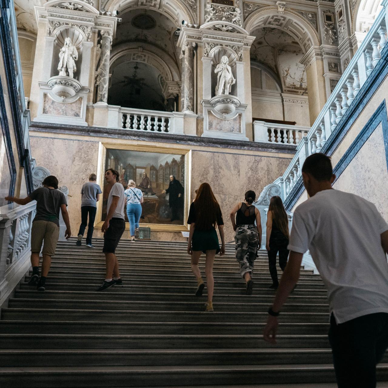 Eine Gruppe von Personen steigt die Treppe des NHM hoch