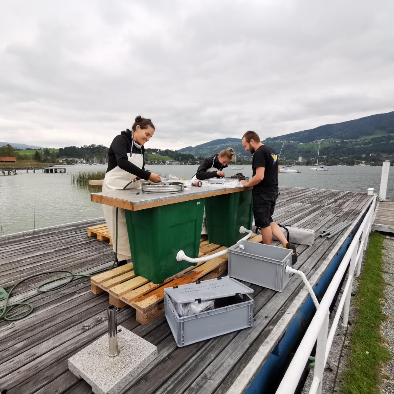 3 Personen arbeiten auf einem Steg an der Schlämmstation