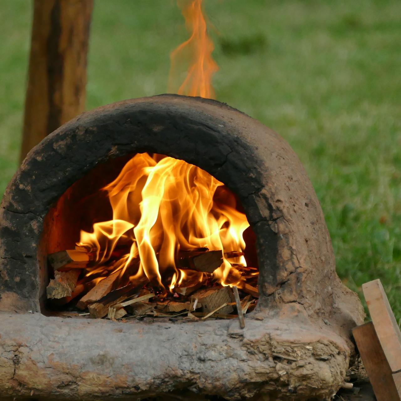 Lehmbackofen mit offenem Feuer beheizt