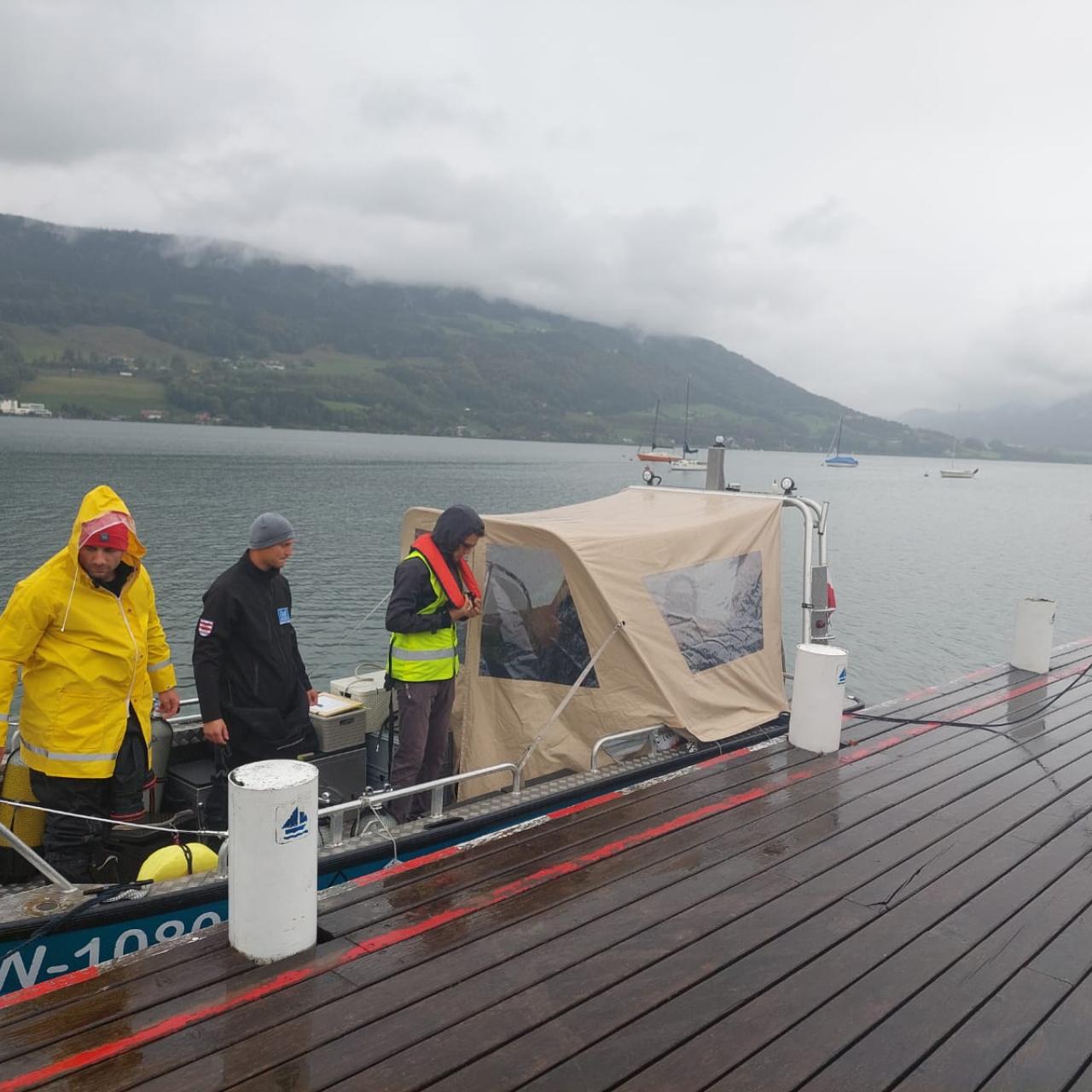 Mehrere Personen steigen auf ein Boot am See