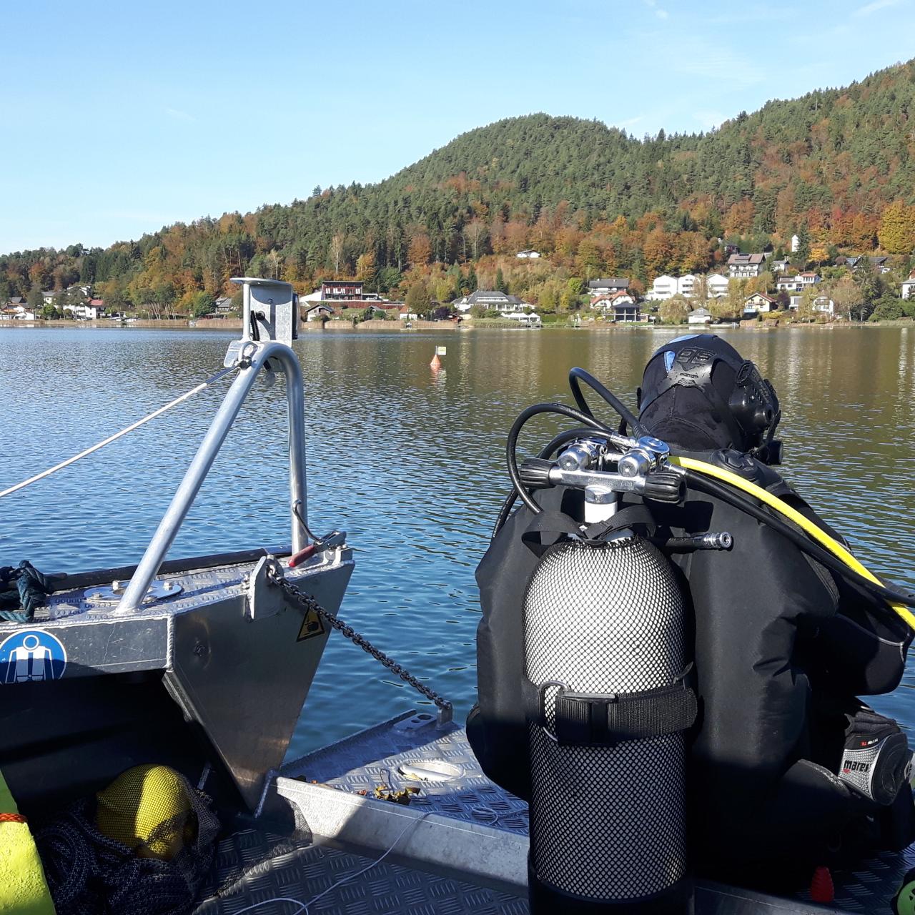 Ein Taucher, der am Boot sitzt, kurz bevor er in den See einsteigt