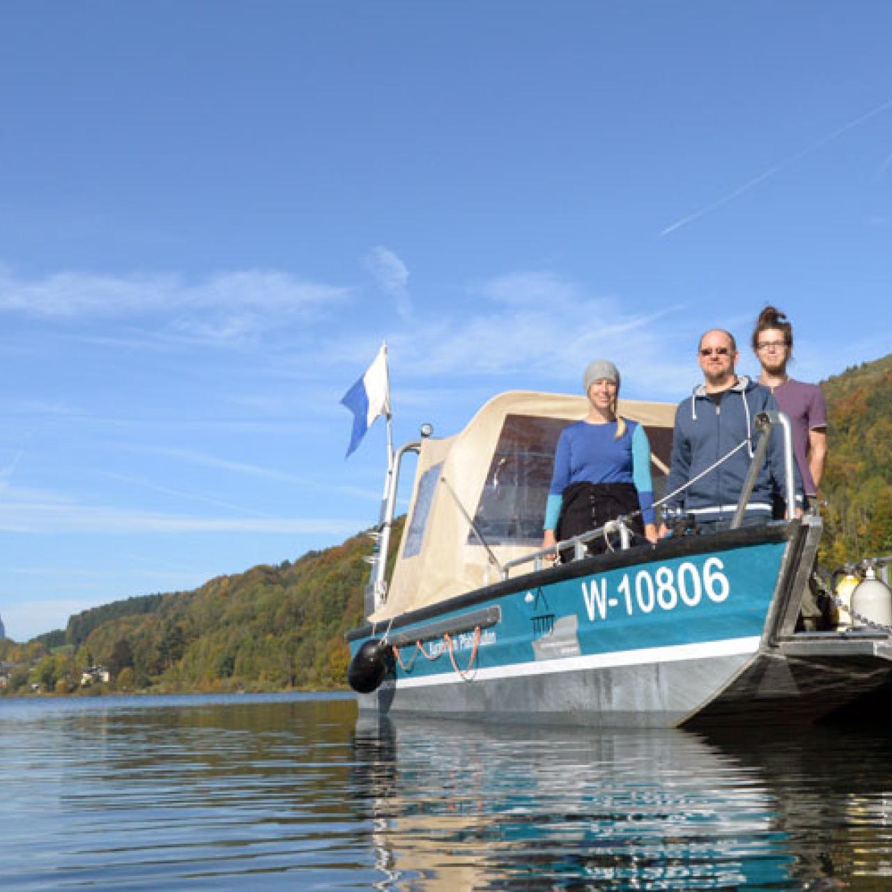 3 Personen auf einem Boot, das im See schwimmt