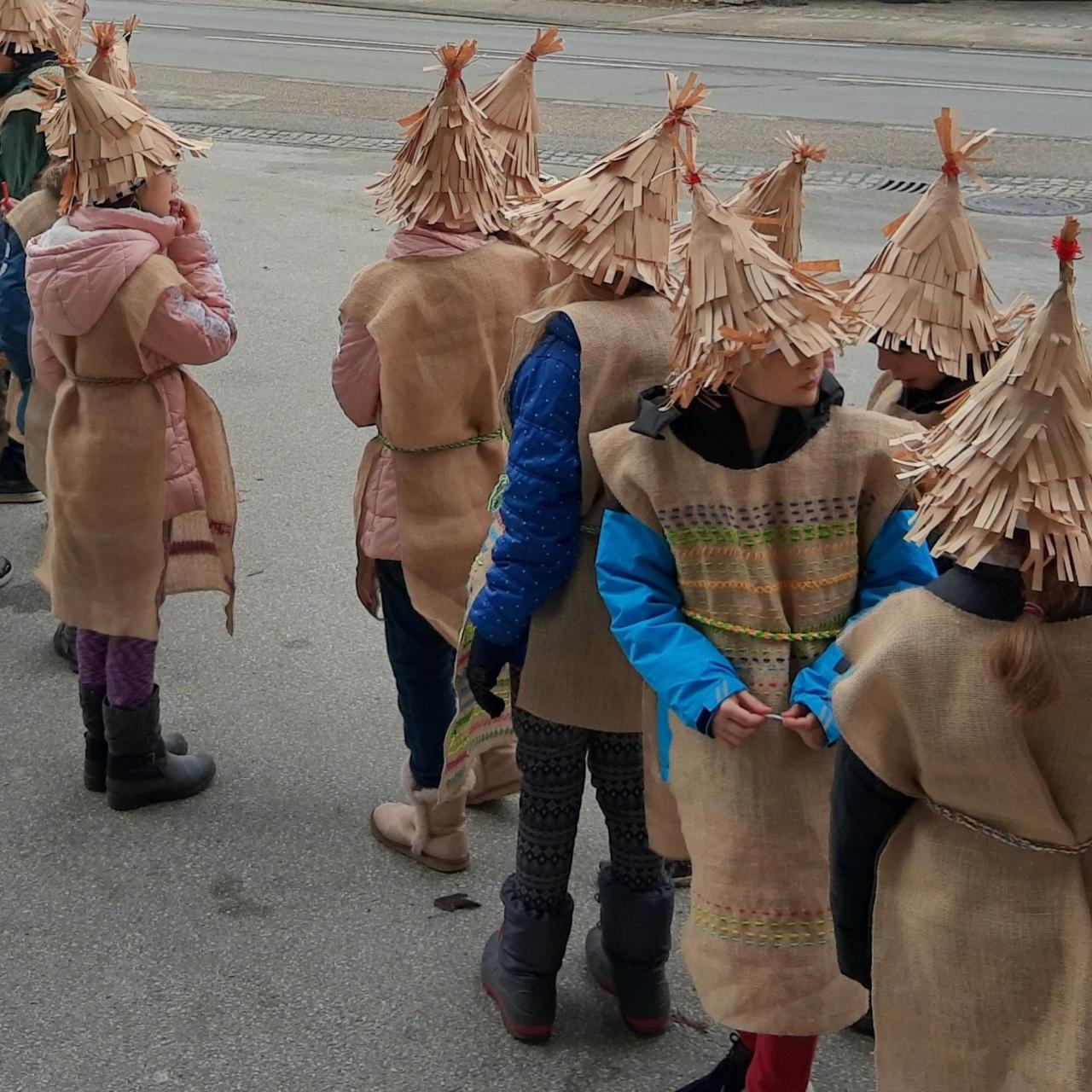 Eine Kindergruppe mit Kostümen aus brauner Jute 