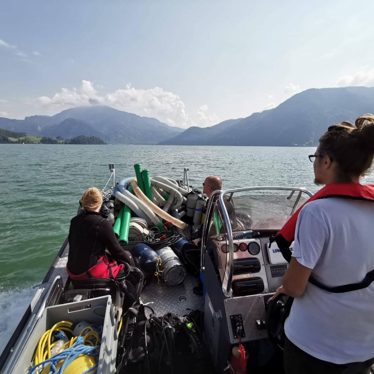 Mehrere Personen auf einem Motorboot am See