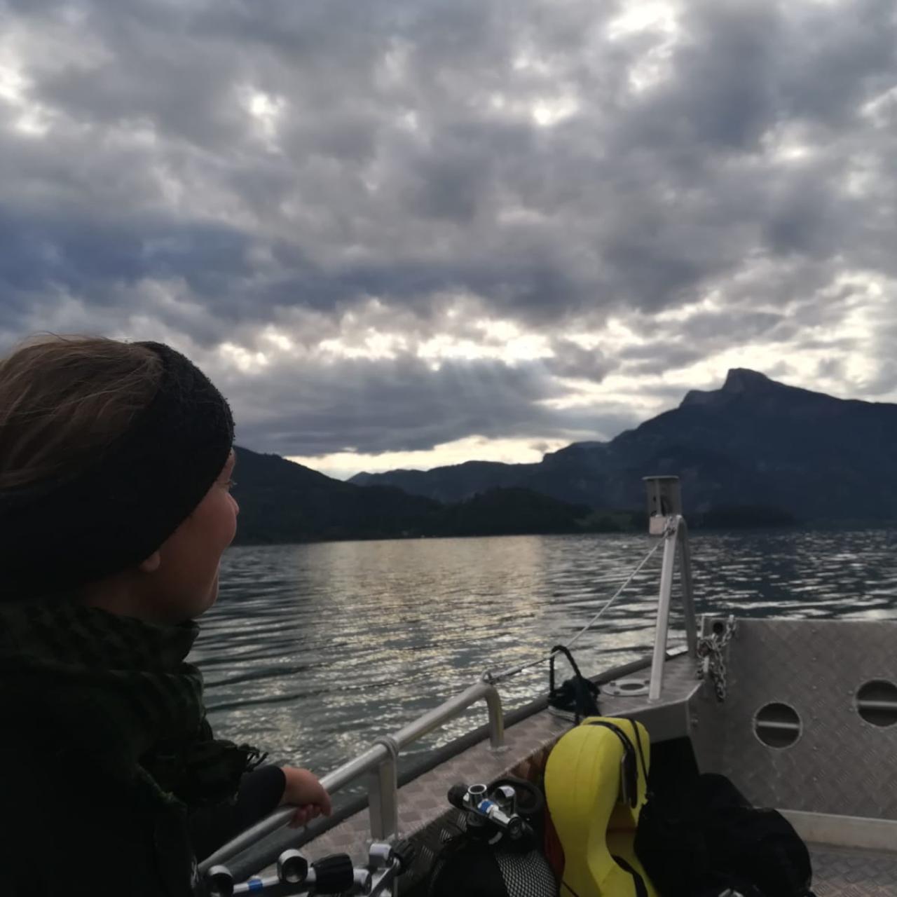 Eine Frau auf einem Boot am See, die Stimmung wirkt düster