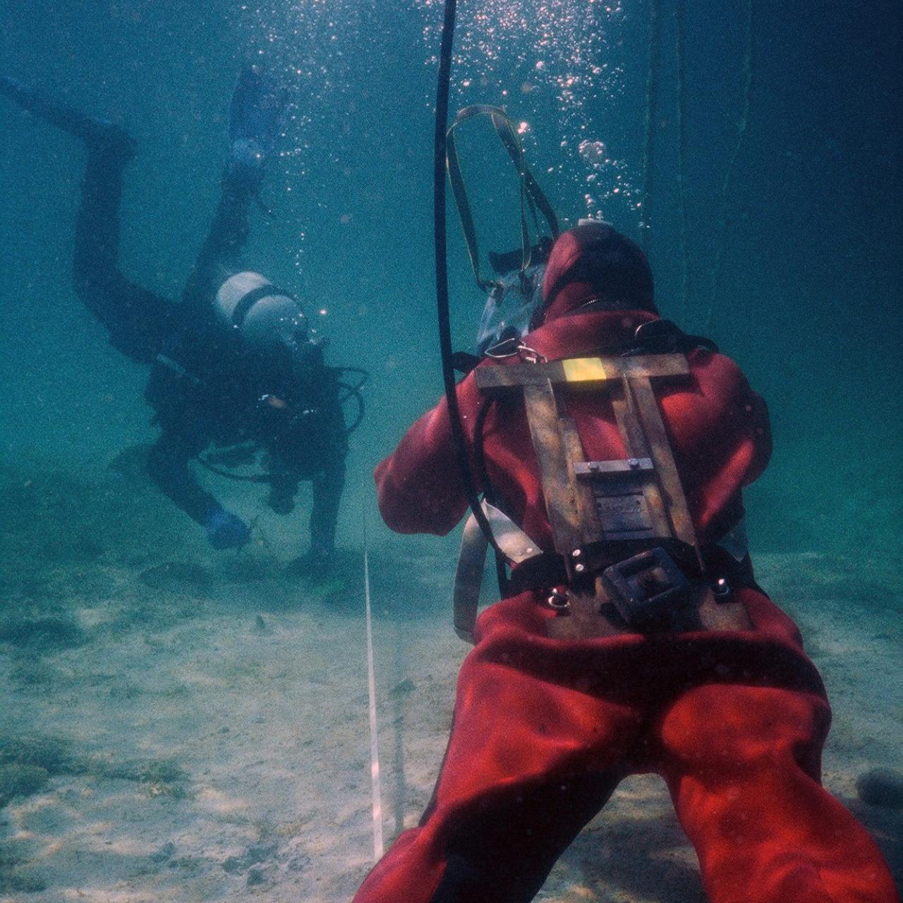 2 Taucher unter Wasser untersuchen den Seeboden