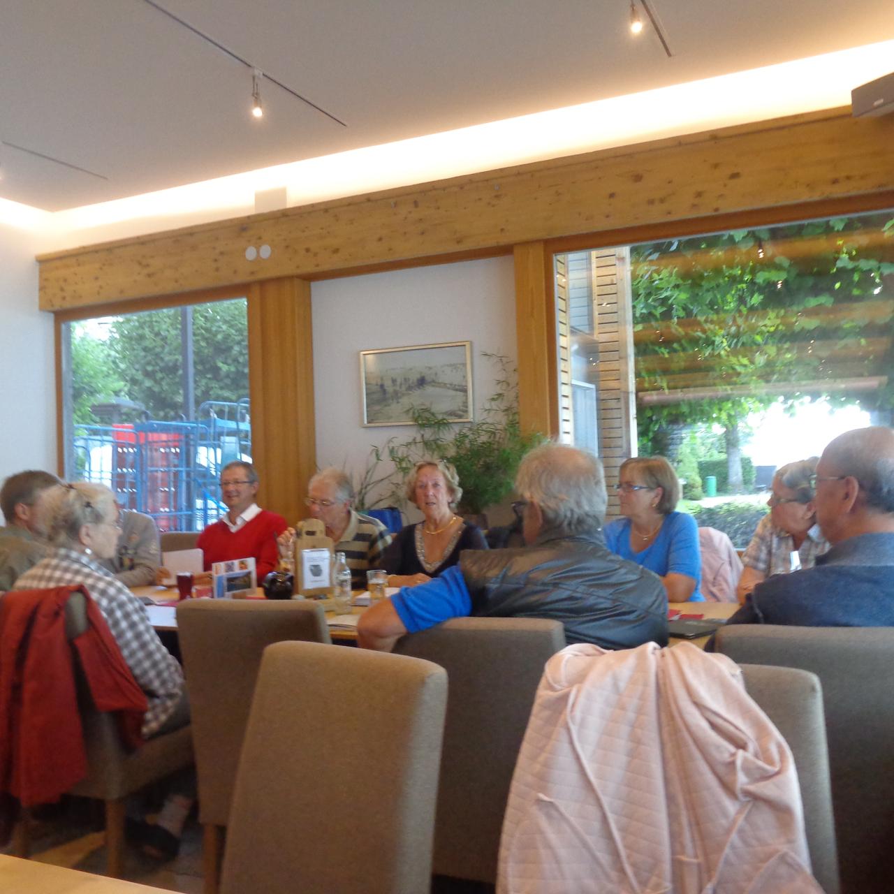 Die Vereinsmitglieder sitzen in einem Gasthaus an einem großen Tisch