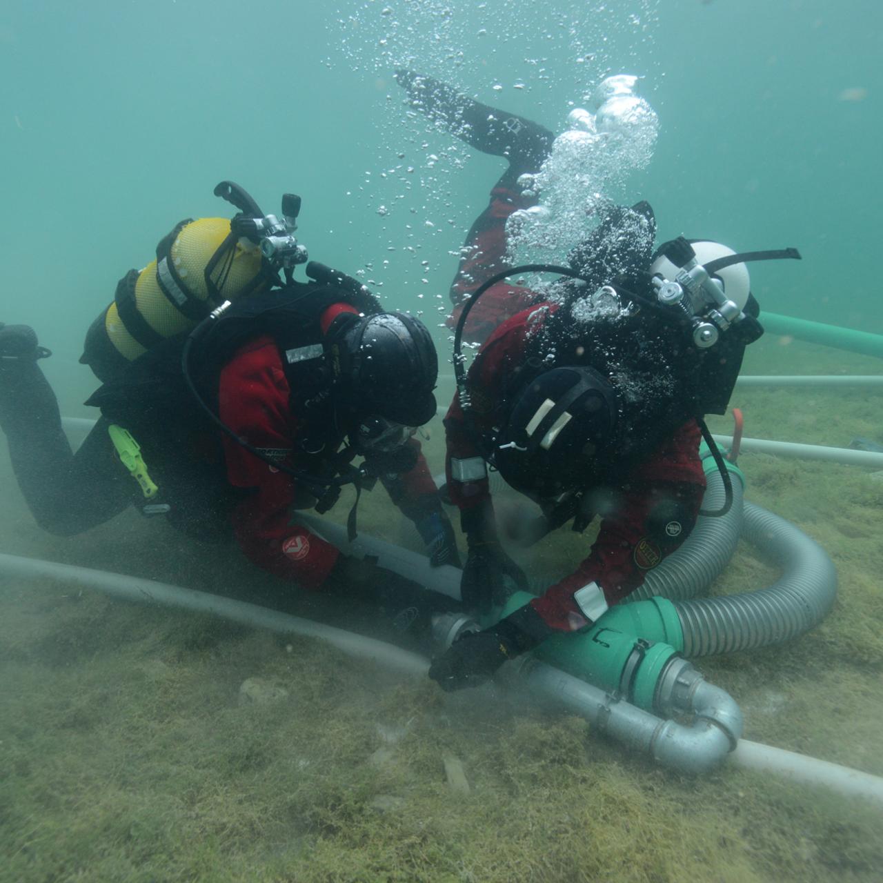 2 Taucher im Unterwasserschnitt bei der Arbeit mit der Dredge