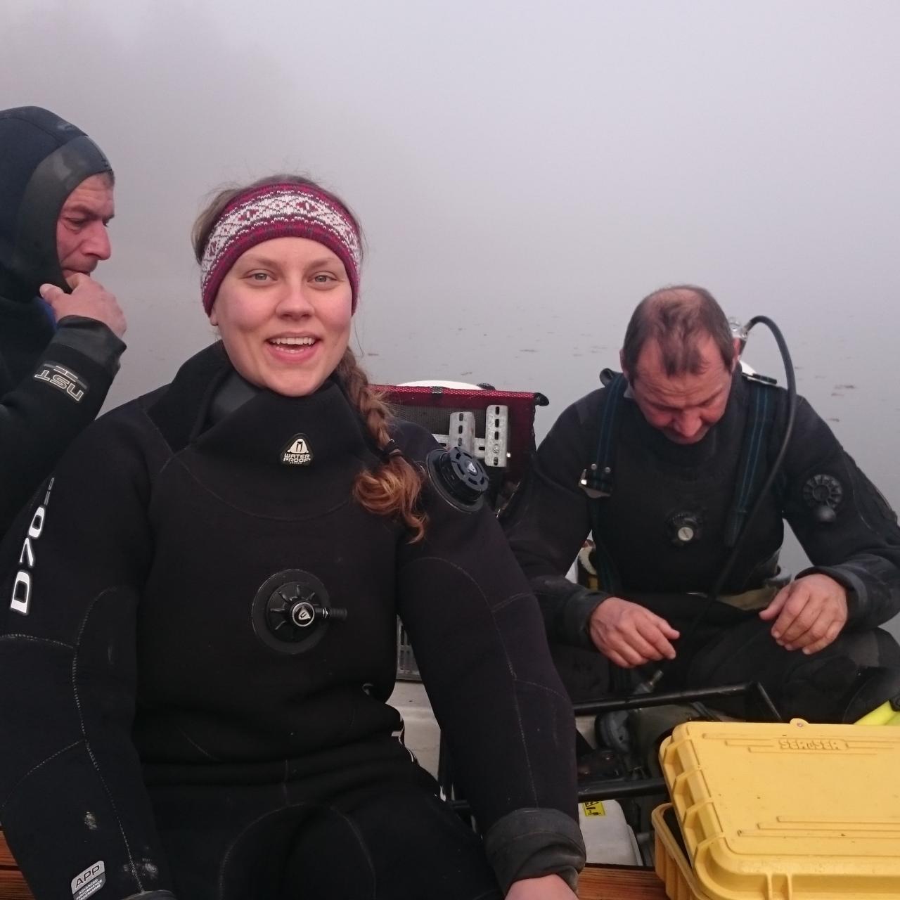 3 Personen sitzen auf einem Boot im Nebel