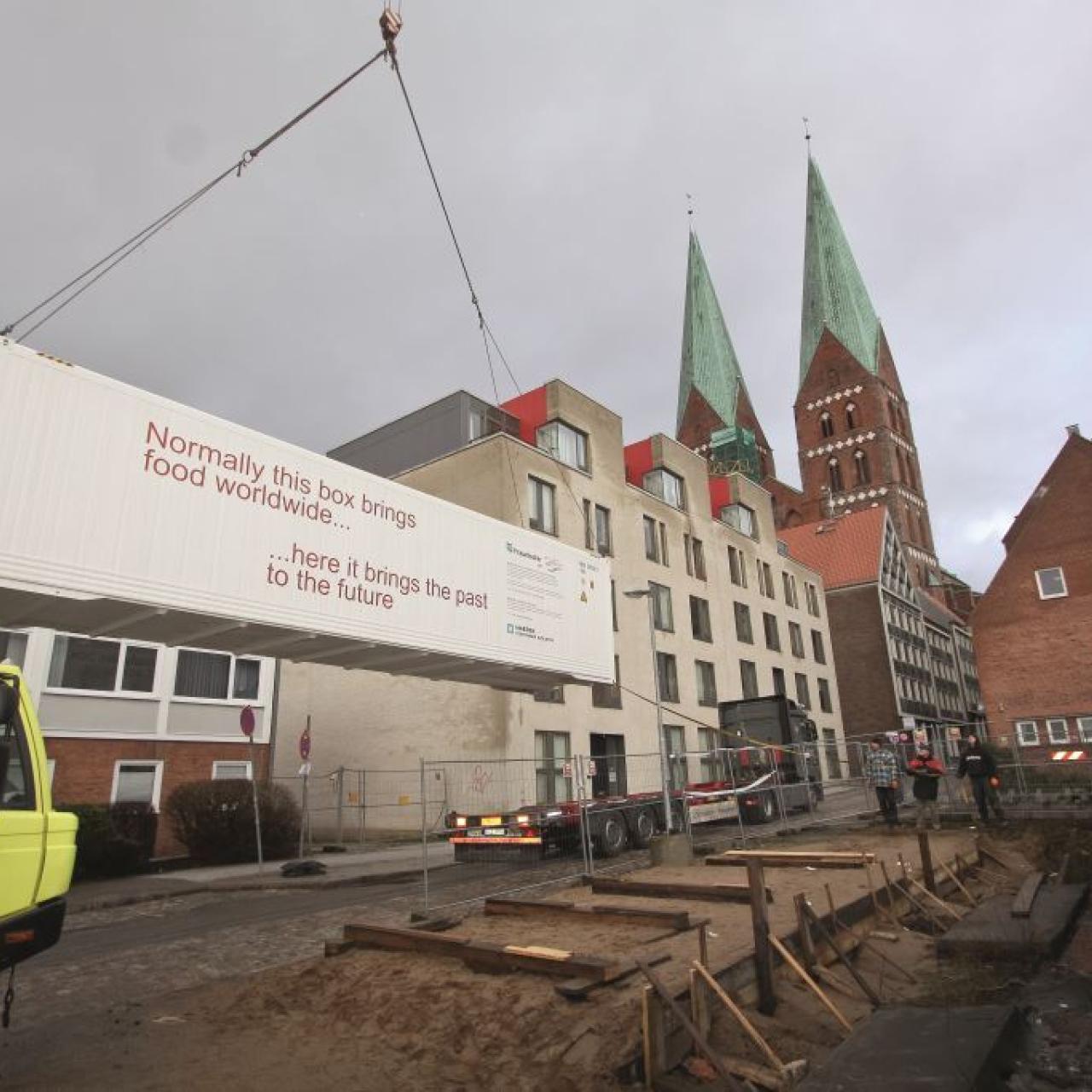 Ein Kran hebt den Container auf den LKW