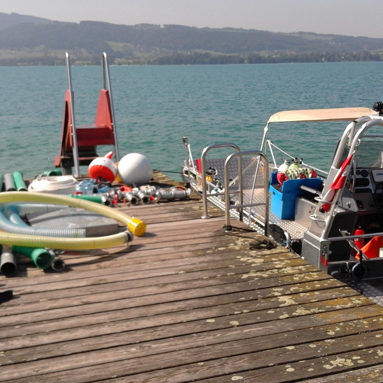 Ein Steg mit Tauchequipment, an dem das Forschungsboot vertäut liegt