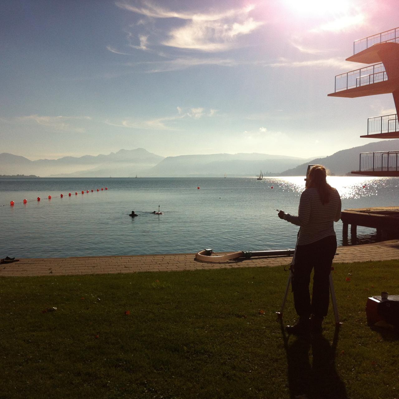 Helena am Tachymeter vor dem Attersee und dem Sprungturm in Seewalchen