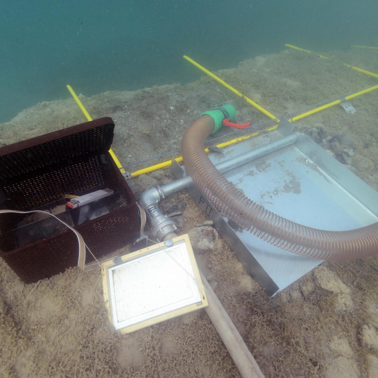 Eine schwarze Box, eine Schreibtafel, die Waterdredge und die Vermessungsrahmen unter Wasser