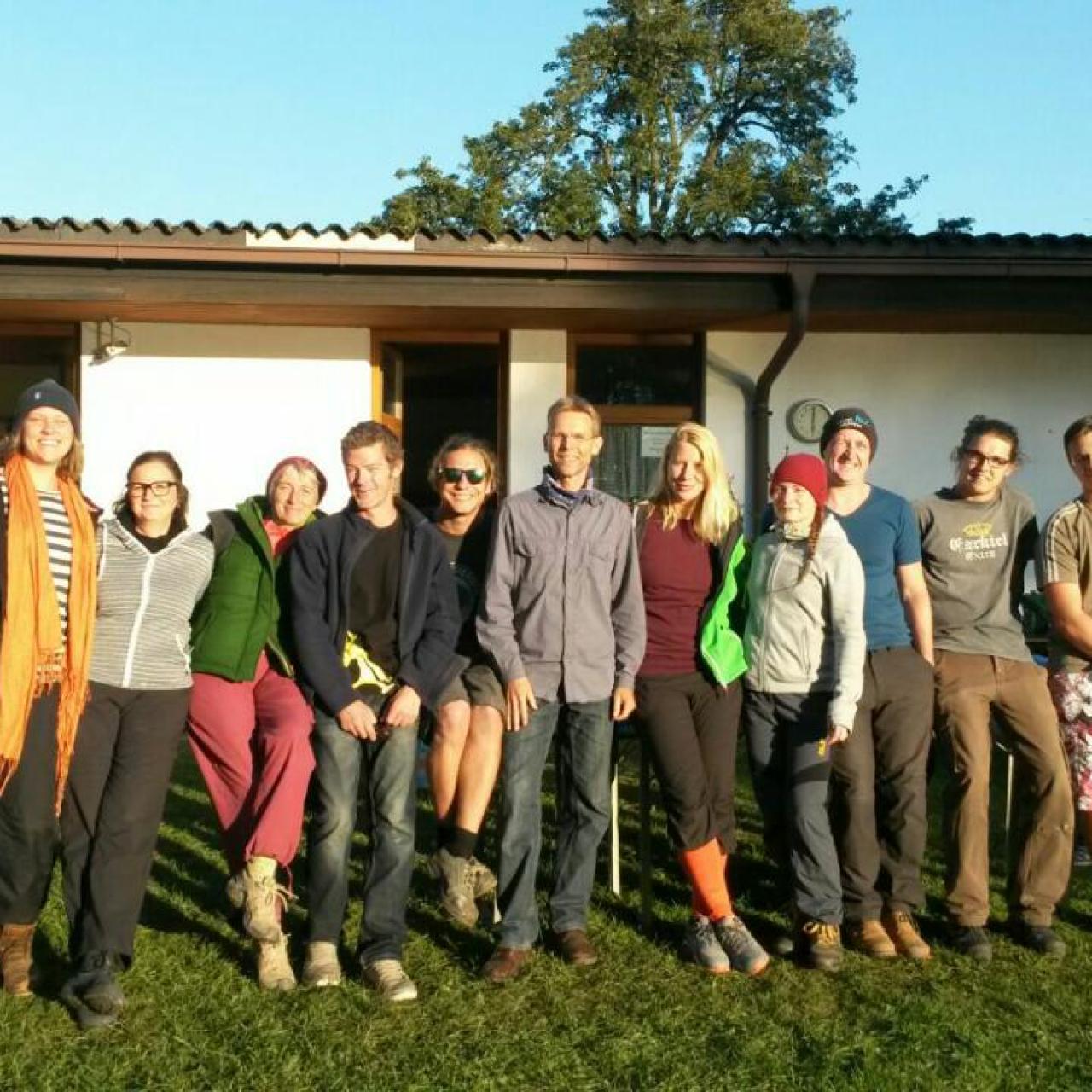 Das Grabungsteam auf einer Wiese vor einem niedrigen Gebäude