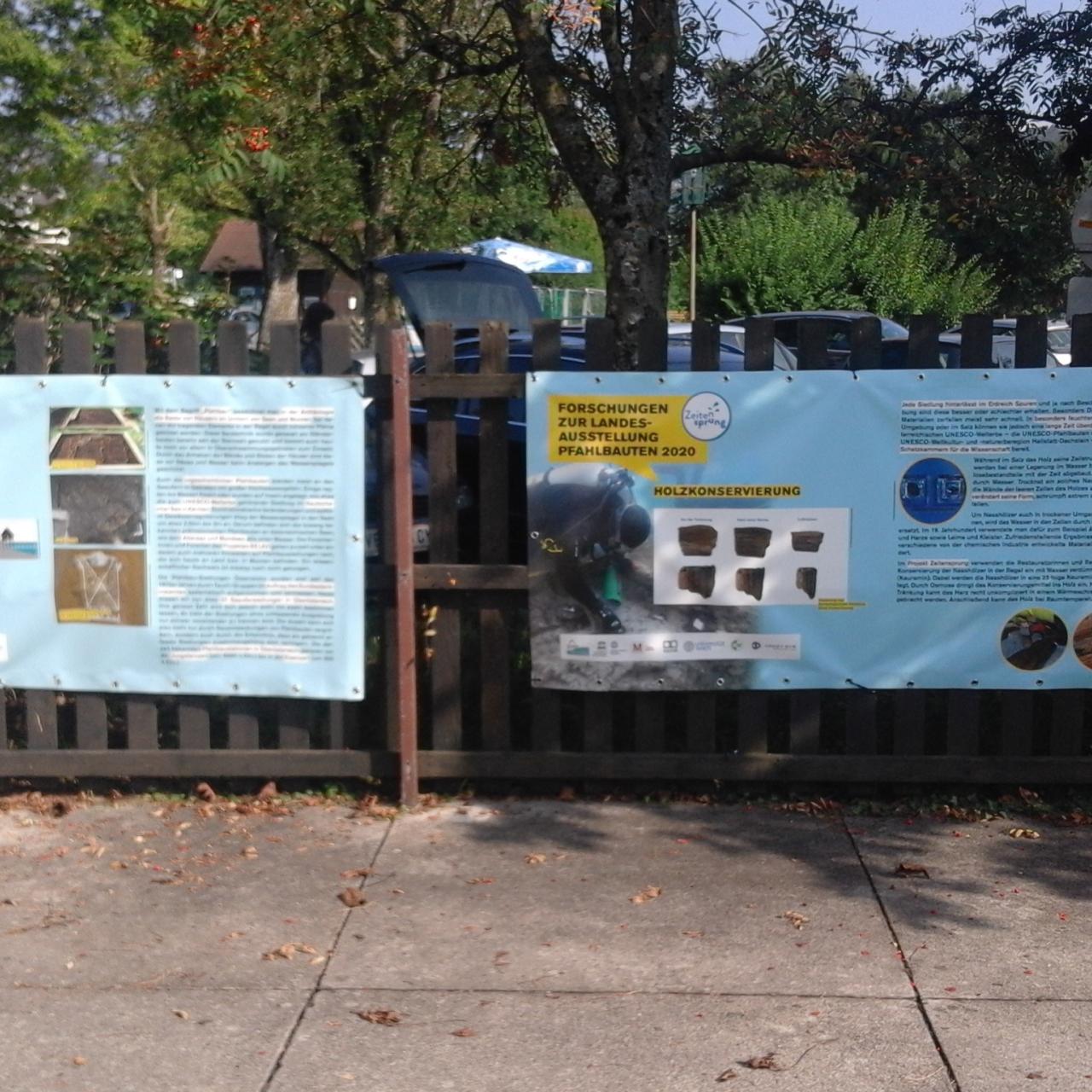 2 Plakate auf einem Zaun montiert
