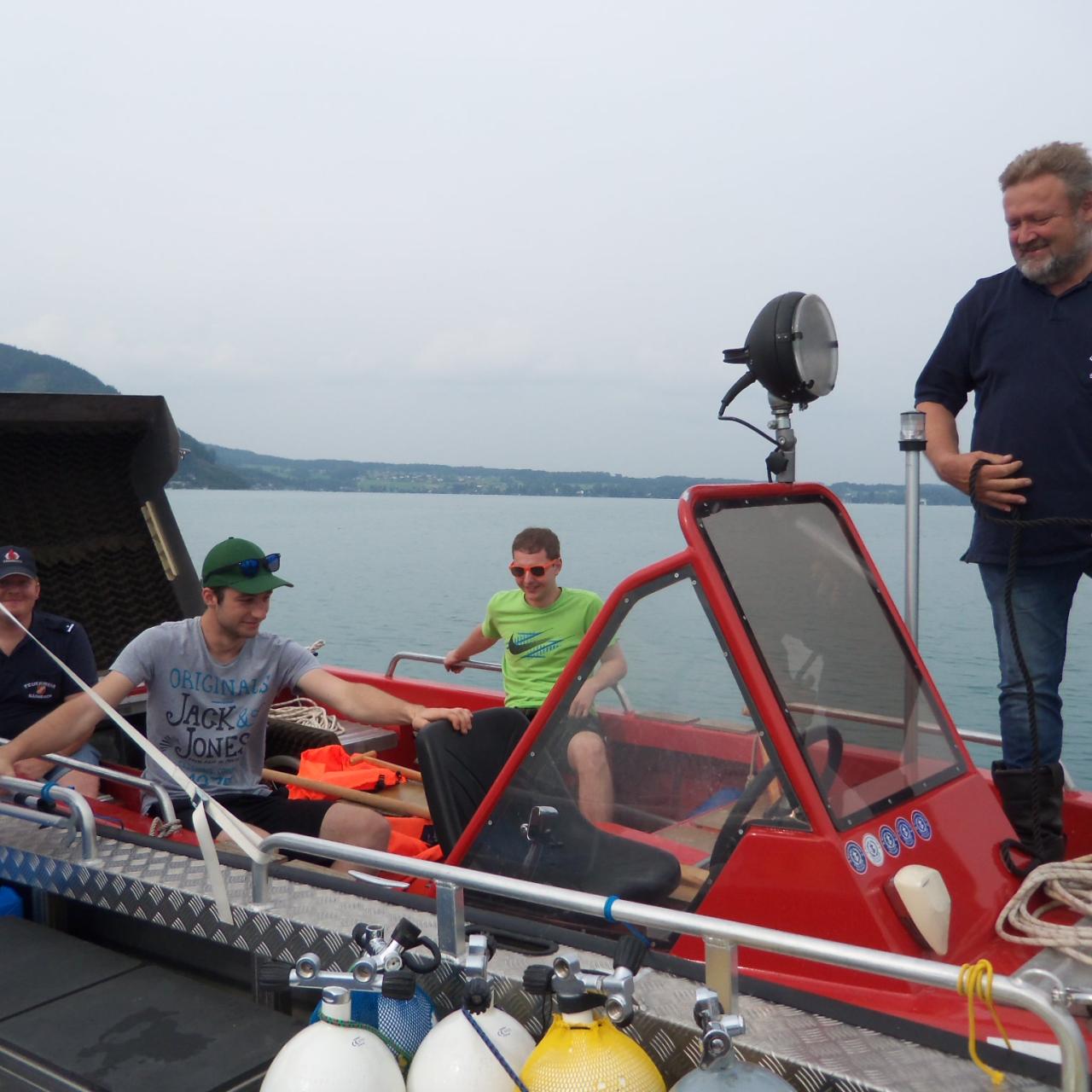 5 Personen auf einem roten Boot